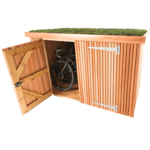 A classic bike shed made of Scottish Larch cladding wood, featuring a vibrant green grass roof. One of its two hinged doors is open, revealing a bicycle stored inside.